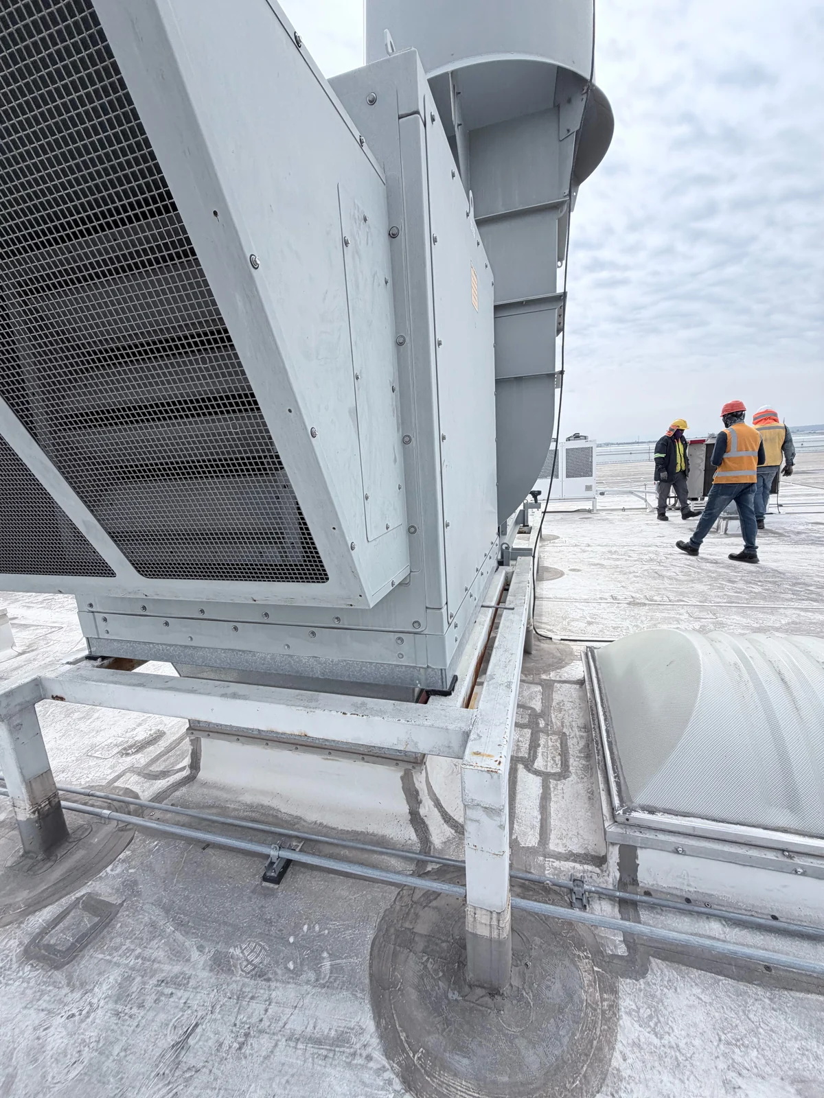 Equipos de climatización y personal técnico en una cubierta industrial